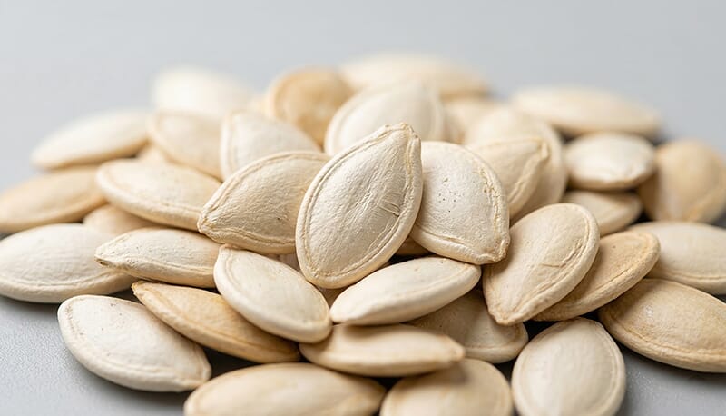 Close-up of premium raw pumpkin seeds, raw material for food processing.